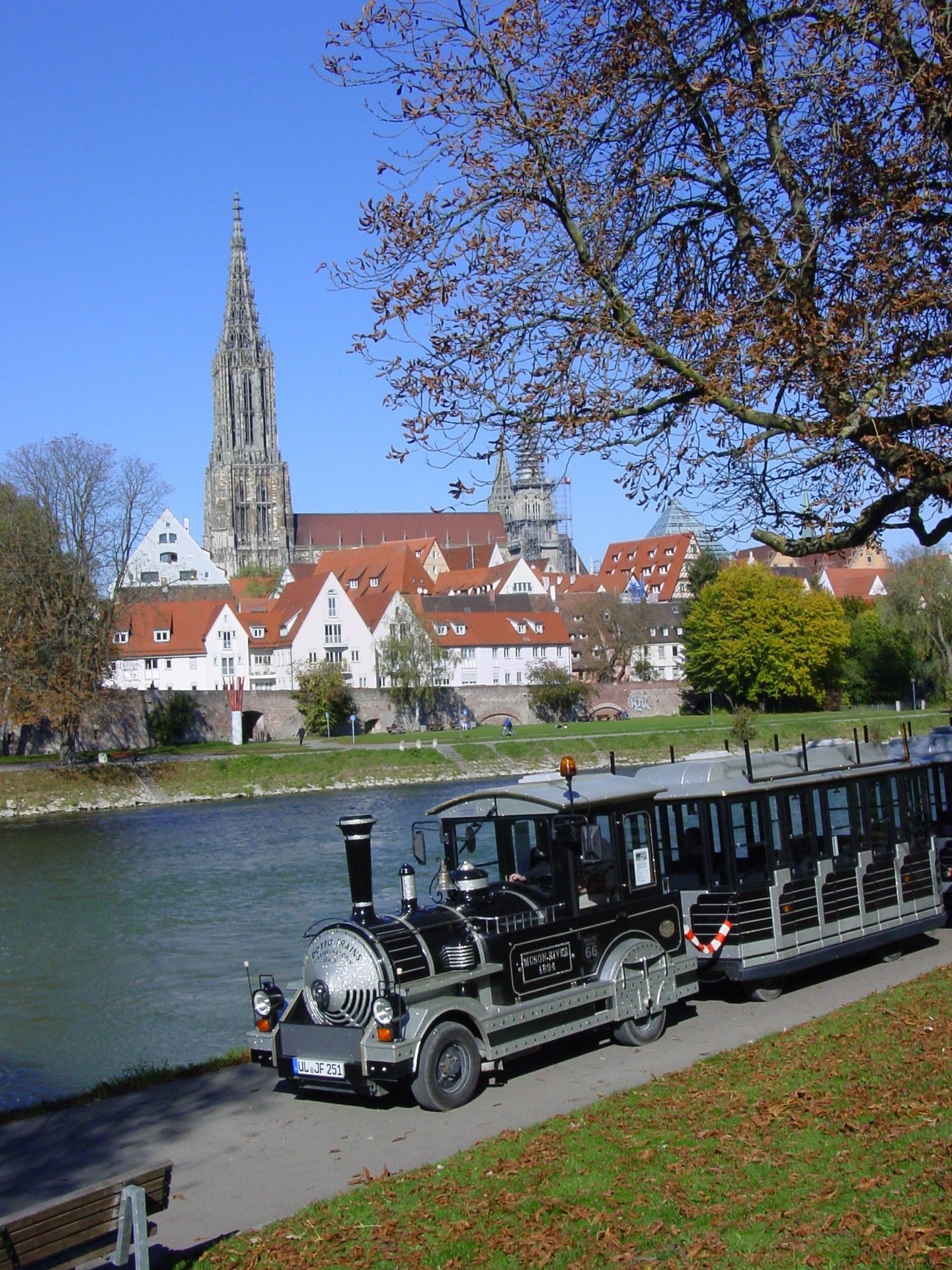 Spatzenbähnle unterwegs entlang der Donau mit Blick auf das Ulmer Münster